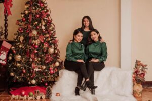 Three girls next to a Christmas tree